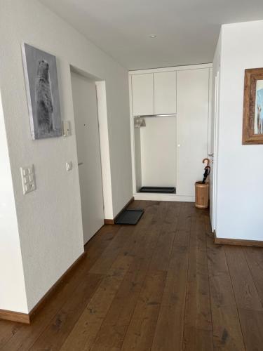 an empty room with white walls and wooden floors at Apartment Bellania in Davos