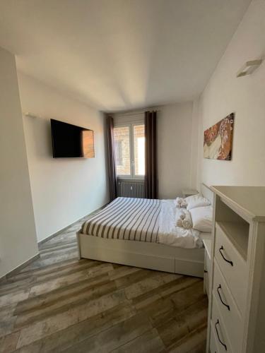 a bedroom with a bed and a tv on the wall at BONBON in Rovigo