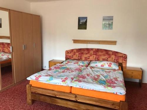 um quarto com uma cama e uma cabeceira em madeira em Apartman Hruba Skala em Hrubá Skála