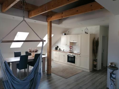 a kitchen and dining room with a hammock in a room at Litti in Worpswede