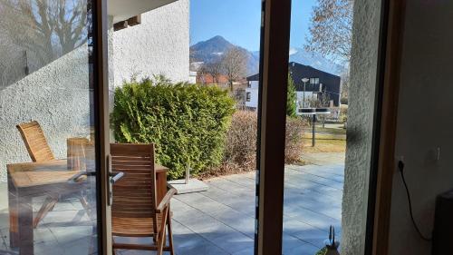 a glass door leading to a patio with a table and chairs at Bungalow mit Terrasse im alpinen Stil in Schliersee