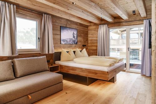 a bedroom with a bed and a couch at Chalets Schladming Ski-in Ski-out in Schladming