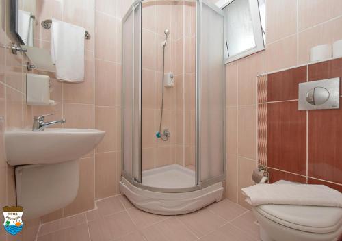 a bathroom with a shower and a toilet and a sink at BODENSEE HOTEL in Antalya