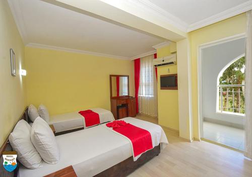 two beds in a room with yellow and yellow walls at BODENSEE HOTEL in Antalya
