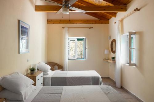 una camera da letto con due letti e un ventilatore a soffitto di Villa Eleni a Gaios