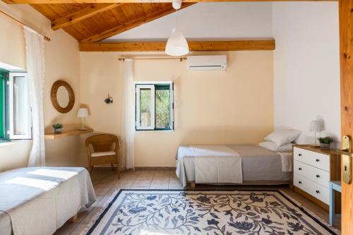 una camera con 2 letti, una scrivania e una sedia di Villa Eleni a Gaios