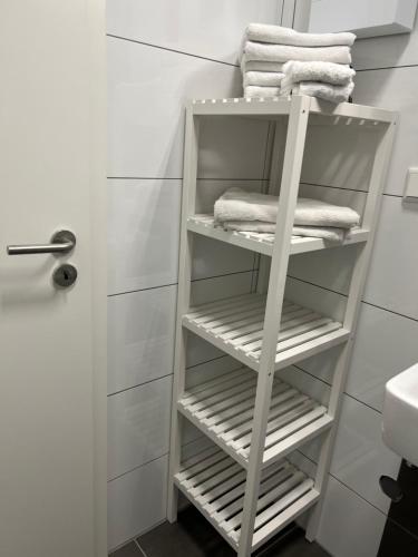 a white towel rack in a bathroom with towels at Freshly renovated City Apartments Essen near Düsseldorf Airport in Essen
