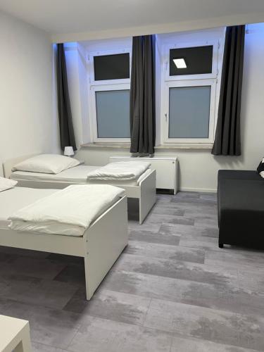 a room with three beds and two windows at Freshly renovated City Apartments Essen near Düsseldorf Airport in Essen