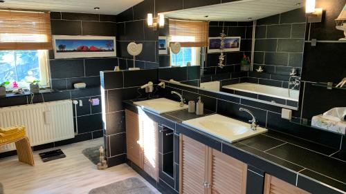 a bathroom with two sinks and a large mirror at YourHome-PM in Michendorf