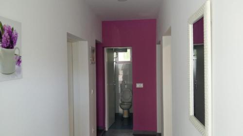 un corridoio con servizi igienici in una camera con pareti viola di Apartmani Slavica a Makarska