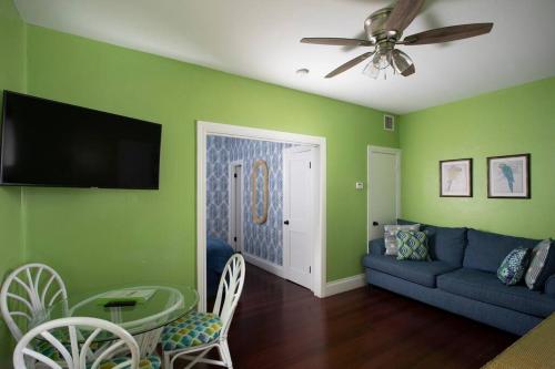 キーウェストにあるDuval Street Suite with poolの緑の壁のリビングルーム(青いソファ付)