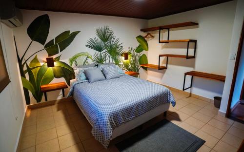 a bedroom with a bed and plants on the wall at Private Tropical Paradise - Gatuncrocs in Cuipo