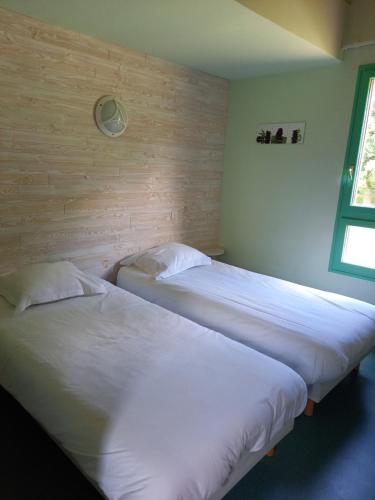 2 camas individuales en una habitación con ventana en Hôtel du golf du coiroux en Aubazines