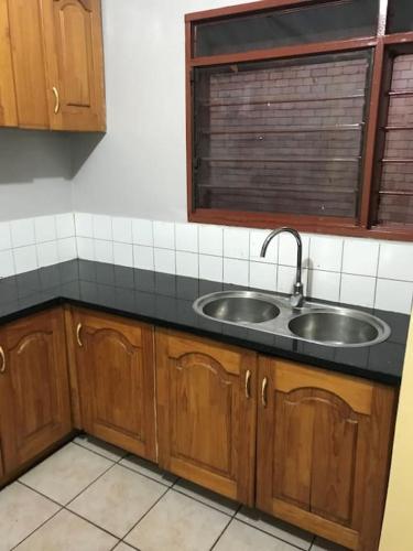 a kitchen with a sink and a window at Ibex Hill Apartment- Power backup in Lusaka