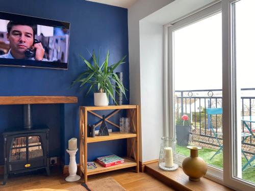 a living room with a fireplace and a tv at Extended Fishermans cottage with stunning sea views in The Mumbles