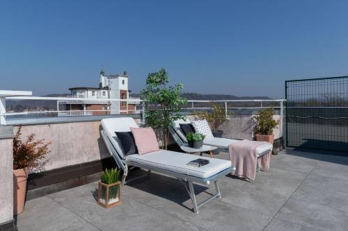 a patio with a table and chairs on a roof at La Terrazza in Castelletto sopra Ticino