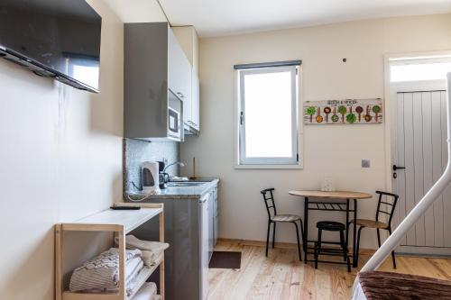 a small kitchen with a sink and a table at House on a rustic Island At Campanha Trainstation in Porto