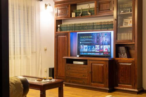 a living room with a large entertainment center with a television at Pensiunea Tara Fagilor in Suceava
