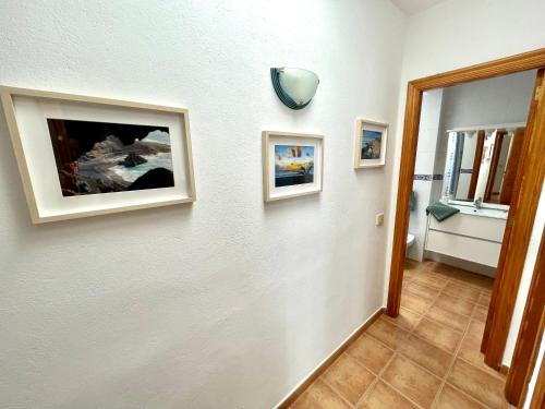 un pasillo con dos cuadros en una pared blanca en Maresía Apartamento en El Golfo