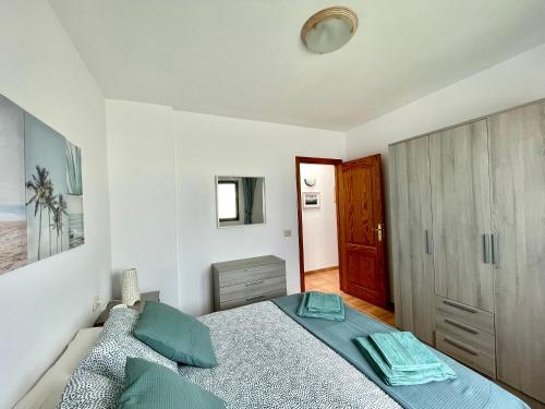 a bedroom with a bed with blue pillows at Maresía Apartamento in El Golfo