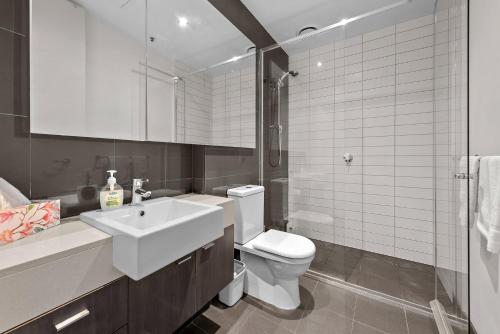 a white bathroom with a sink and a toilet at Exclusive Stays - SXY in Melbourne