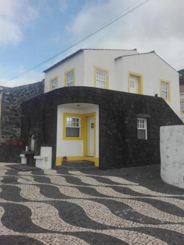 a black and white building with a yellow door at Alojamento Bela Vista in Lajes do Pico