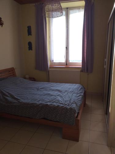 1 dormitorio con 1 cama y una ventana con cortinas moradas en Sympathique T3 près lac du Bourget, en Serrières-en-Chautagne