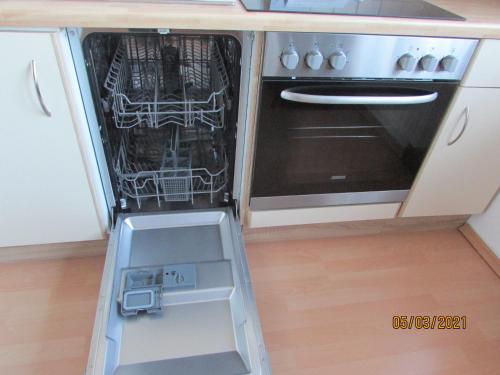 an open dishwasher in a kitchen next to a stove at Apartments bei Familie Liebl in Sankt Oswald