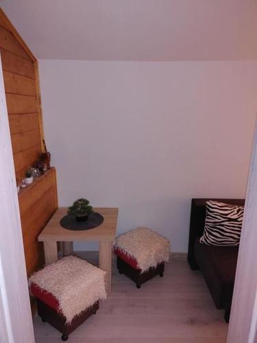 a room with a table and two stools and a bed at Zacisze u Ani in Siemiany