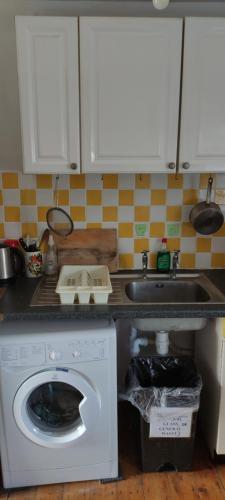 a kitchen with a washing machine and a sink at Toad Hall Hostel in Machynlleth