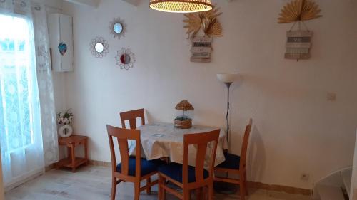 ein Esszimmer mit einem Tisch und Stühlen in der Unterkunft Location d'un pavillon de vacances in Marseillan