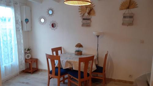 a dining room with a table and chairs at Location d'un pavillon de vacances in Marseillan