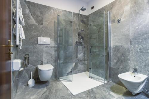 a bathroom with a shower and a toilet and a sink at Ancora Sport Resort Hotel in Meolo