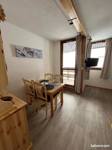 une salle à manger avec une table et des chaises et une fenêtre dans l'établissement Duplex la Plagne Montalbert, à Aime La Plagne