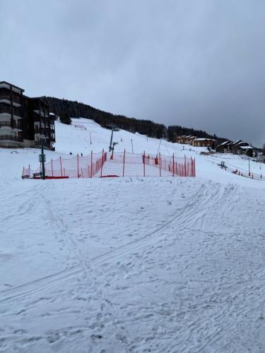 een met sneeuw bedekte skipiste met een rood hek bij Duplex la Plagne Montalbert in Aime La Plagne
