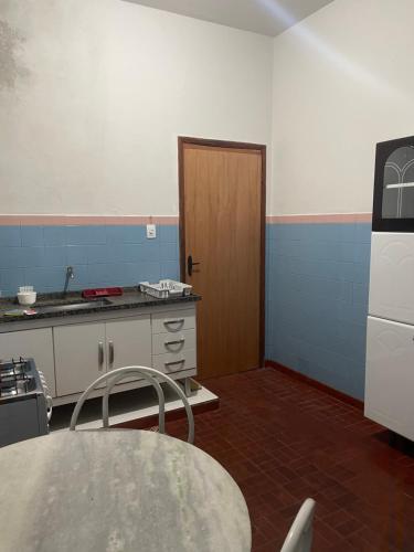 a kitchen with a table and a door in a room at Apartamento Temporada in Passos