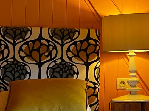 a bedroom with a bed with a black and white wall at Art et Création in Saint-Bérain