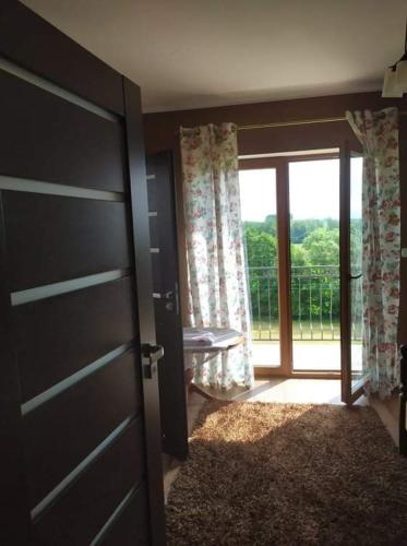 a door to a room with a view of a balcony at Przy Trójstyku in Dubeninki