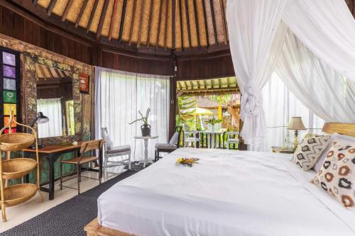 a bedroom with a bed and a table and chairs at Bali Brothers Guesthouse in Dalung