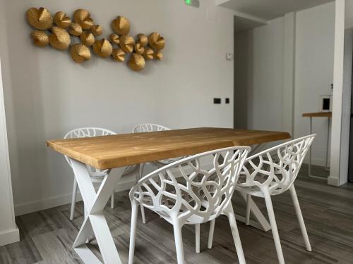 - une table à manger blanche avec des chaises blanches dans l'établissement Rotonda del Minotauro Apartamento Turístico, à Coria