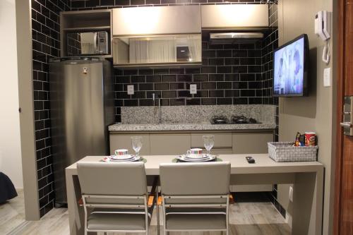 a kitchen with a table with chairs and a refrigerator at Flats Monsenhor31 - Localizado no centro da cidade in Paulo Afonso