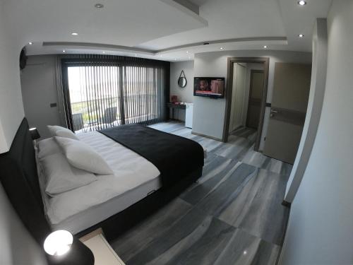 - une chambre avec un grand lit et une grande fenêtre dans l'établissement DKD DELÜXE, à Izmir