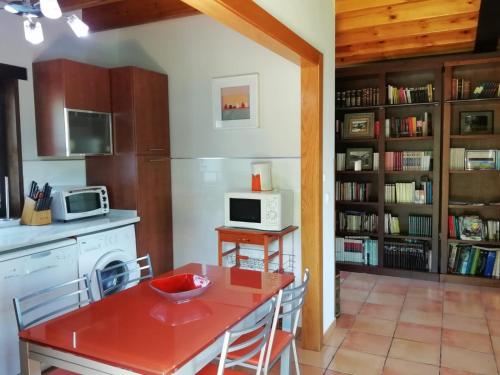 a kitchen with a red table and a microwave at El Oteru II in Gancedo