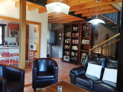 a living room with leather furniture and a kitchen at El Oteru II in Gancedo