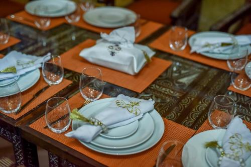 a table with white plates and wine glasses on it at Agafay Pearl Camp Marrakech in Marrakech