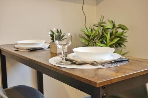 a table with two bowls and a wine glass on it at ❂ Les Logis de la Trémoille ❂ Cozy ❂ Netflix ❂ in Thouars