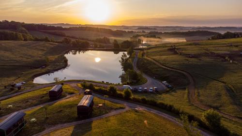 an aerial view of a lake with the sunset in the background at Domaine d'Escapa in Estipouy
