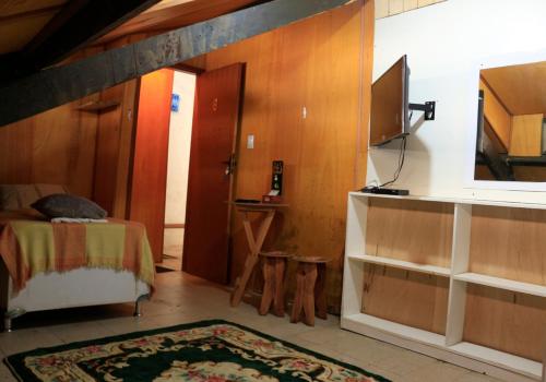a bedroom with a bed and a tv in a room at Pousadinha Copacabana in Rio de Janeiro