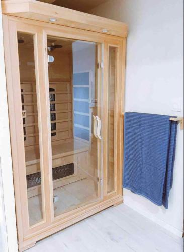 une armoire en bois avec une porte en verre dans une pièce dans l'établissement Le Nuits Saint Georges, à Nuits-Saint-Georges