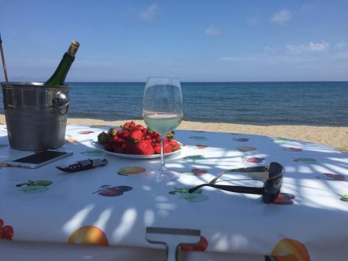 einen Tisch mit einem Glas Wein am Strand in der Unterkunft Casa Anavicente ON the beach in Calnegre